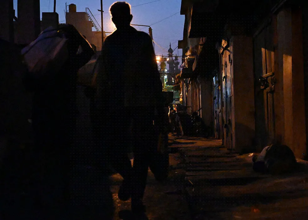 A father and his two sons are hurrying along, carrying vegetable bags. 